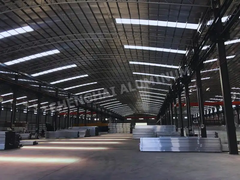 Gran almacén industrial que almacena paquetes de perfiles de extrusión de aluminio terminados.